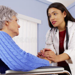 hispanic woman doctor comforting disabled elderly patient mexican women