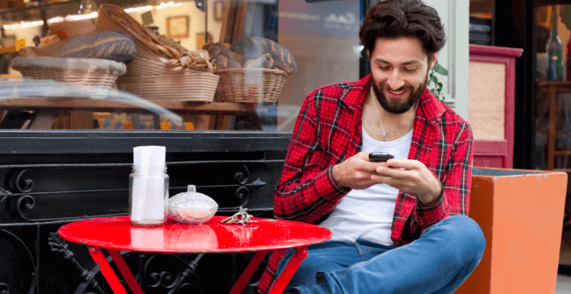 man looking at mobile phone in café e