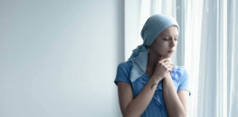 cancer survivor deep in thought standing by the window shutterstock