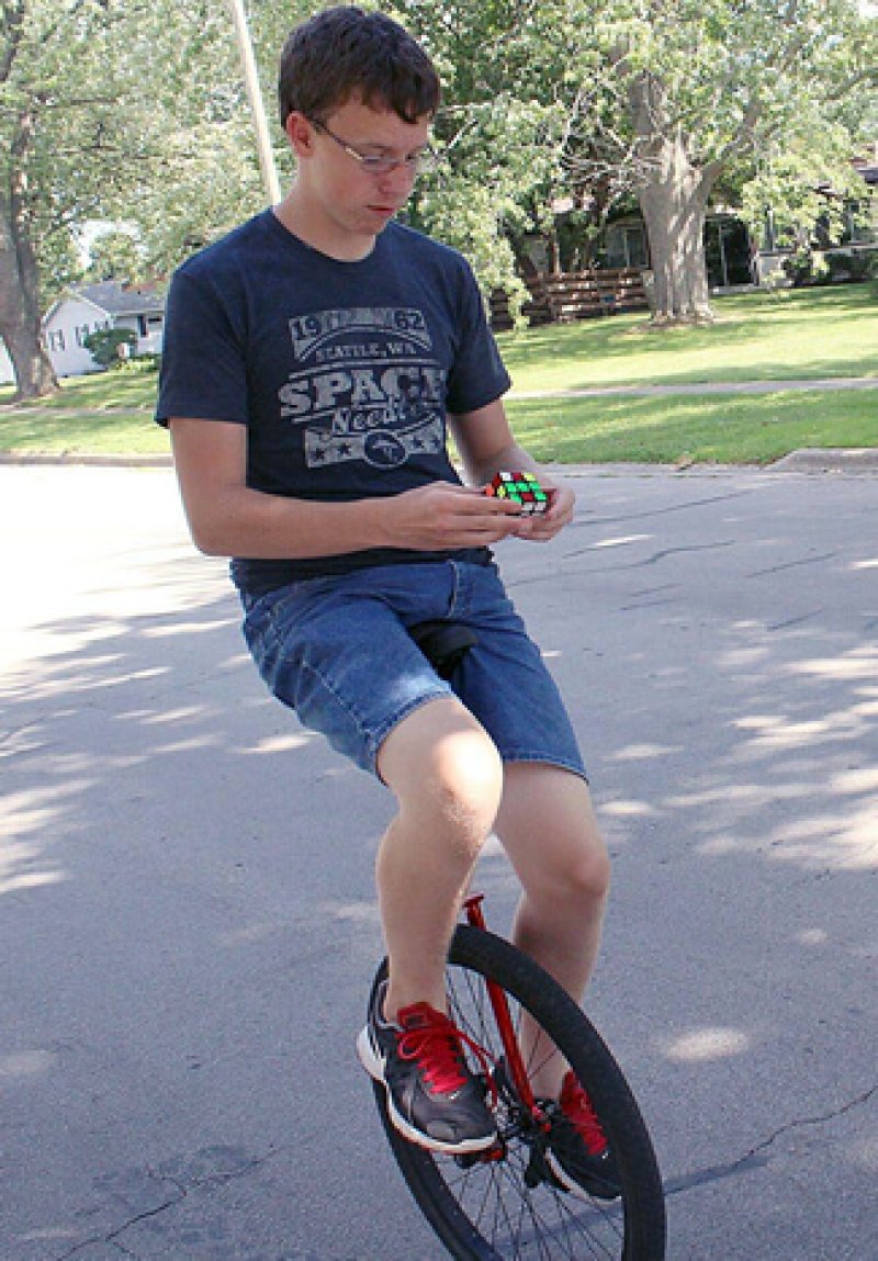 b most Rubiks cubes solved while riding a unicycle