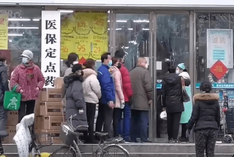 citizens of wuhan lining up outside of a drug store to buy masks during the wuhan coronavirus outbreak