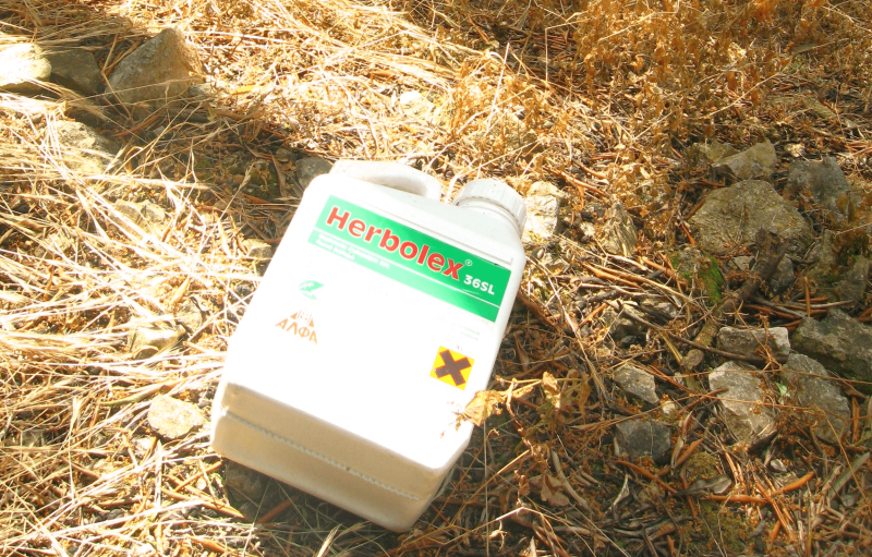 empty glyphosate herbolex container discarded in corfu olive grove