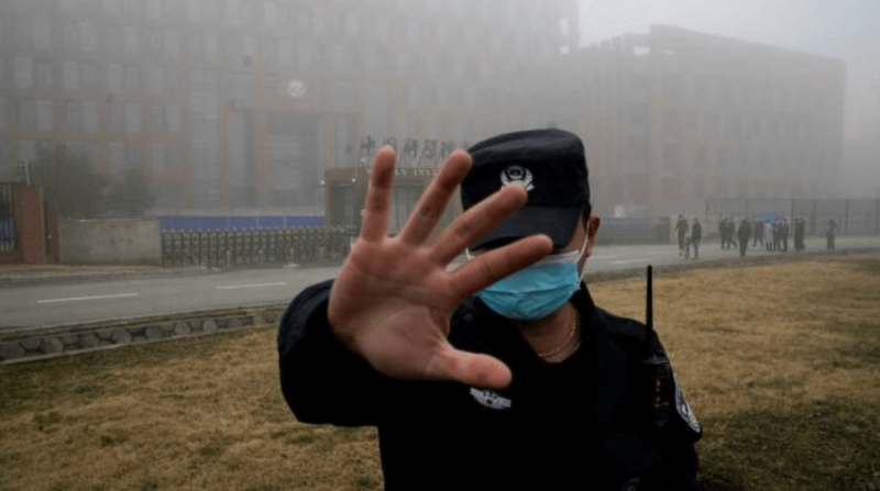 A security guard blocks journalists from the Wuhan Institute of Virology during a visit by World Health Organization investigators. Credit: AP