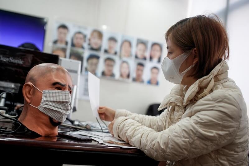A software engineer at Hanwang Technology in Beijing tests a facial-recognition programme that identifies people wearing face masks. Credit: Thomas Peter/Reuters