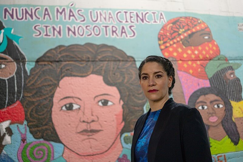 Vivette García Deister is an ethnographer of science at UNAM. The mural says “Never again a science without us” in Spanish. Credit: Stephania Corpi Arnaud for Nature