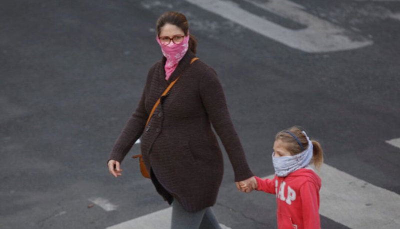 pregnant woman and child walk with masks during covid outbreak x