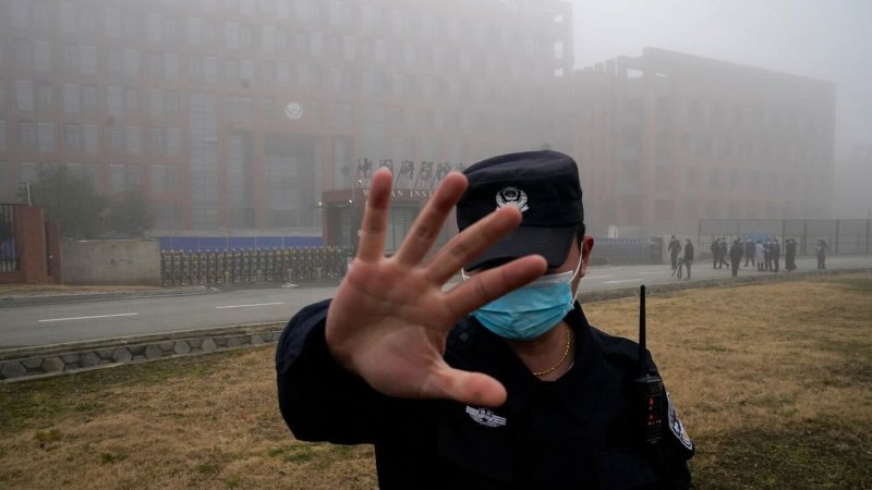 Security moves journalists away from the Wuhan Institute of Virology. Credit: Ng Han Guan/AP